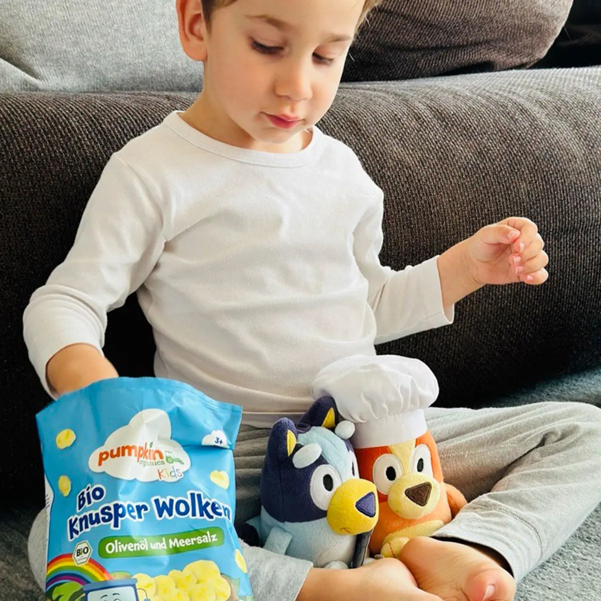 Kind spiel mit Bluey und snackt dabei