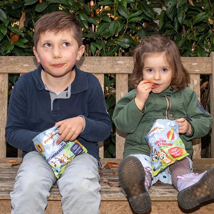 Kind spiel mit Bluey und snackt dabei