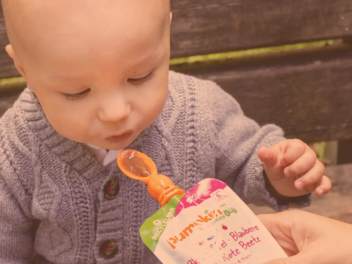 Baby mit Gemüse-Quetschie