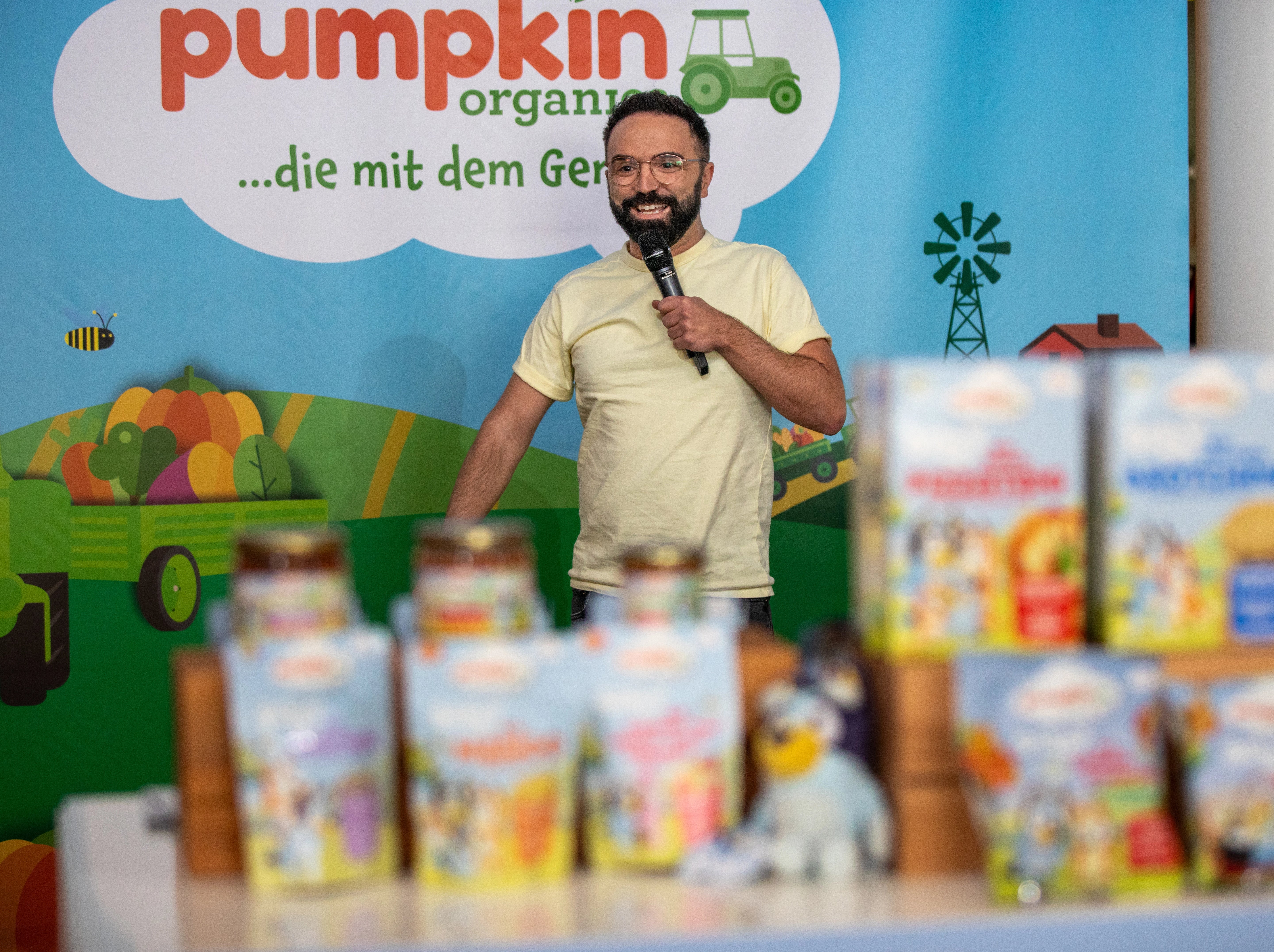Kids.Doc mit Mikro in der Hand vor einem Pumpkin Organics Plakat
