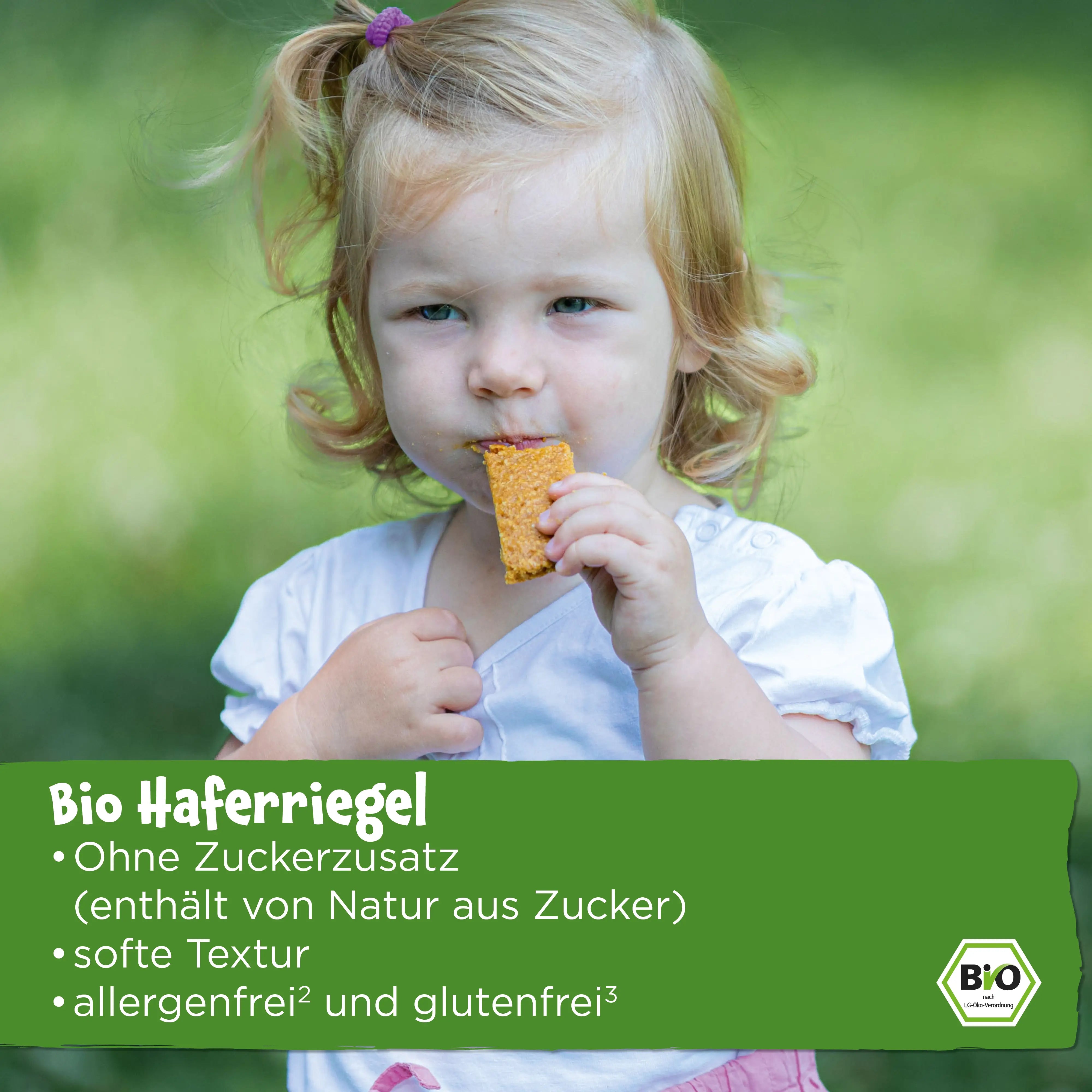 Kind in der Natur, welches einen Pumpkin Organics Bio Haferriegel isst; ohne Zuckerzusatz (enthält von Natur aus Zucker), softe Textur, allergenfrei und glutenfrei