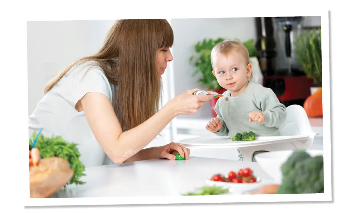Eine Frau füttern ihr Baby mit einem Bio Gemüse-Quetschie von Pumpkin Organcis